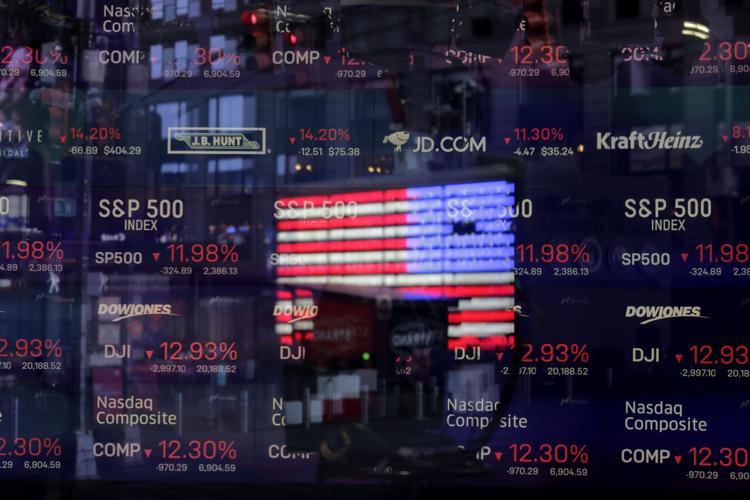 In this March 16, 2020 file photo, a United States flag is reflected in the window of the Nasdaq studio, which displays indices and stocks down, in Times Square, New York. Nasdaq is looking to become more diverse, proposing new rules that would require all companies listed on its U.S. exchange to publicly disclose consistent, transparent diversity statistics about their board of directors. The listing rules would also require most Nasdaq-listed companies to have, or explain why they don’t have, at least two diverse directors.
